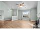 Open living room featuring wood floors, a ceiling fan, large windows, and a fireplace at 322 Equinox Cir, Ladson, SC 29456