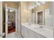 Bright bathroom featuring a double vanity with marble floors, decorative lighting, and an open doorway to a bedroom at 3334 Merion Pl, Mount Pleasant, SC 29466