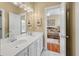 Bright bathroom with double vanity, marble floors, decorative mirror, and open doorway to a separate bedroom at 3334 Merion Pl, Mount Pleasant, SC 29466