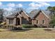 Charming brick home featuring a manicured lawn, mature trees, and detailed architectural elements at 3334 Merion Pl, Mount Pleasant, SC 29466