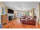 Living room with fireplace, hardwood floors, natural lighting, and an oversized leather couch at 3334 Merion Pl, Mount Pleasant, SC 29466