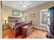 Bedroom features hardwood floors, two windows, and a statement wood bed frame with detailed accents and wood chest at 3334 Merion Pl, Mount Pleasant, SC 29466