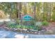 Community entrance sign surrounded by colorful flowers and lush greenery at 3334 Merion Pl, Mount Pleasant, SC 29466