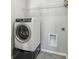 Bright laundry room features a white washer, tile flooring, and overhead storage at 3920 Hanoverian Dr, Mount Pleasant, SC 29429
