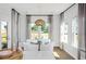 Bright dining area with modern light fixture, view of back yard through large windows, and hardwood flooring at 564 Richfield Way, Summerville, SC 29486