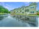 Green two-story townhomes featuring matching facades, white trim, and a wet parking lot at 704 Twin Rivers Dr # 44, Wando, SC 29492