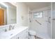 Bright bathroom featuring a white vanity, walk in shower with grab bars and tiled walls at 7639 Northhaven Dr, North Charleston, SC 29420