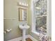 Bathroom with pedestal sink and a window offering natural light and wooded views at 7938 Pelican Bay Dr, Awendaw, SC 29429