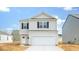 Charming two-story home with a light gray exterior, black shutters, a large garage and a concrete driveway at 838 Lilyford Ln, Summerville, SC 29486