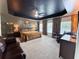 Spacious main bedroom with a tray ceiling, large windows, comfortable seating, and a luxurious king-size bed at 9656 Pebble Creek Blvd, Summerville, SC 29485
