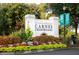 Welcome to Carnes Crossroads sign adorned with colorful flowers and lush greenery, creating an inviting entrance at 972 Carnes Crossing Blvd, Summerville, SC 29486