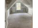 An unfinished attic with a dormer window, exposed framing, and subfloor at Ln, Walterboro, SC 29488