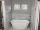 Modern bathroom featuring a standalone tub with marble-patterned tile and bright windows at Ln, Walterboro, SC 29488