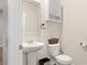 Half bathroom with a pedestal sink, toilet, decorative mirror, and cabinet, perfect for guests at 103 Cardinal Flower Ct, Moncks Corner, SC 29461