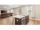 Open-concept kitchen island with stainless steel appliances, granite counters, bar stool seating and hardwood floors at 103 Cardinal Flower Ct, Moncks Corner, SC 29461