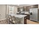 Modern kitchen with stainless steel appliances, granite counters, island with bar seating and gray cabinets at 103 Cardinal Flower Ct, Moncks Corner, SC 29461