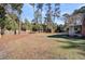 View of a spacious backyard, framed by mature trees and fencing, offering privacy and room for outdoor activities at 108 Tea Farm Rd, Summerville, SC 29483