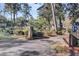 View of circular driveway with brick pillars leading to a lush property surrounded by trees and manicured hedges at 108 Tea Farm Rd, Summerville, SC 29483