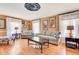 Comfortable living room showcasing hardwood floors, neutral sofas, and ample natural light from large windows at 108 Tea Farm Rd, Summerville, SC 29483