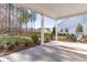Covered back porch with a concrete floor, offering a serene view of the wooded backyard at 116 Threaded Fern St, Summerville, SC 29485