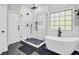 Modern bathroom features a glass-enclosed shower, soaking tub, and stylish black and white tile at 1208 Red Buckeye Ct, Moncks Corner, SC 29461
