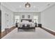 Spacious bedroom with tray ceiling and hardwood floors featuring a sitting area, and neutral color palette at 1208 Red Buckeye Ct, Moncks Corner, SC 29461