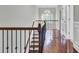 Upstairs hallway with wood staircase, decorative wrought iron railing, and natural light at 1208 Red Buckeye Ct, Moncks Corner, SC 29461