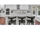 Modern kitchen features an island with bar seating, stainless steel appliances, and stylish backsplash at 1208 Red Buckeye Ct, Moncks Corner, SC 29461