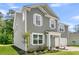 Side view of a two-story home with a well-kept lawn, tidy landscaping, and attached garage at 121 Loon Dr, Summerville, SC 29483