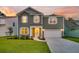 Charming two-story home with manicured lawn, gray siding, white trim, and a two-car garage at sunset at 121 Loon Dr, Summerville, SC 29483