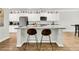 Spacious kitchen island with a granite countertop, bar stool seating and decorative shelving above the white cabinets at 121 Loon Dr, Summerville, SC 29483