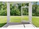 View from the screened porch to the green backyard with lush trees at 121 Loon Dr, Summerville, SC 29483