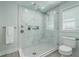 Bathroom with glass enclosed tile shower featuring rainfall shower head, bench, and a window for natural light at 1247 Oakcrest Dr, Charleston, SC 29412