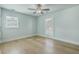Light and airy bedroom with hardwood floors, ceiling fan, and two large windows at 1247 Oakcrest Dr, Charleston, SC 29412