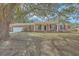 Charming brick home featuring a covered porch, mature tree and an attached garage at 1247 Oakcrest Dr, Charleston, SC 29412