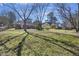 Large backyard with grass and a treeline with multiple structures at 127 Ridge Rd, Summerville, SC 29485