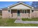 Charming brick home featuring a quaint front porch, complemented by manicured landscaping and a welcoming green door at 127 Ridge Rd, Summerville, SC 29485