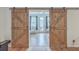 Rustic sliding barn doors leading into a well-lit home office with backyard access at 132 Mcclellan Way, Summerville, SC 29483