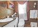 A vintage bathroom featuring a white sink, commode, and bathtub with distinctive wallpaper and decor at 133 Stephanie Cir, Summerville, SC 29483