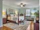 Spacious main bedroom with a four-poster bed, sitting area, ceiling fan, and plush rug on hardwood floors at 135 Ashley Hill Dr, Goose Creek, SC 29445