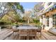 An expansive backyard with mature trees, a spacious deck and patio, and beautiful landscaping at 14 Guerard Rd, Charleston, SC 29407