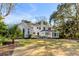 Expansive green backyard with a lush lawn, brick house, and patio seating creates a perfect outdoor oasis at 14 Guerard Rd, Charleston, SC 29407