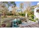 A serene backyard featuring a large, well-manicured lawn and brick patio with comfortable seating at 14 Guerard Rd, Charleston, SC 29407