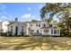 Beautiful backyard showcasing a pristine lawn, patio area, and elegant white brick home at 14 Guerard Rd, Charleston, SC 29407