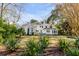 Lush backyard with a pristine lawn, mature trees, and a patio creates an inviting outdoor retreat at 14 Guerard Rd, Charleston, SC 29407