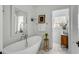 Bright bathroom with a freestanding tub, marble floors, decorative art, and lots of natural light at 14 Guerard Rd, Charleston, SC 29407
