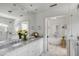 Bright bathroom with a dual-sink vanity, marble countertops, and a soaking tub at 14 Guerard Rd, Charleston, SC 29407