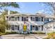 Charming two-story brick home with a bright yellow front door, manicured landscaping, and circular driveway at 14 Guerard Rd, Charleston, SC 29407