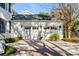 Attached two-car garage featuring carriage-style doors, complemented by lush landscaping and a brick-lined driveway at 14 Guerard Rd, Charleston, SC 29407