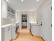 Bright laundry room with white cabinets, modern washer and dryer, sink, and view into the pantry at 14 Guerard Rd, Charleston, SC 29407